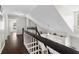 Upstairs hallway with dark hardwood floors and white railing leads to bedrooms and overlooks the living room below at 11207 Donneymoor Dr, Riverview, FL 33569