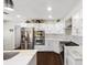 Modern kitchen features stainless steel appliances, marble countertops, white cabinets, and dark hardwood floors at 11207 Donneymoor Dr, Riverview, FL 33569