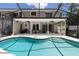 Screened-in pool area offers a covered patio, outdoor seating, and lush landscaping for relaxation and leisure at 11207 Donneymoor Dr, Riverview, FL 33569
