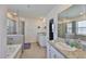 Bright bathroom with granite counters, tiled floors, a glass enclosed shower and a soaking tub at 11924 Brighton Knoll Loop, Riverview, FL 33579