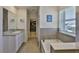 Bright bathroom with granite counters, a walk-in closet, a soaking tub and a window at 11924 Brighton Knoll Loop, Riverview, FL 33579