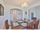Elegant dining room featuring a chandelier, table with four chairs, and an arched doorway at 11924 Brighton Knoll Loop, Riverview, FL 33579