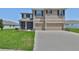 Inviting two-story home featuring a well-manicured lawn and attached two-car garage with tan paint and black shutters at 11924 Brighton Knoll Loop, Riverview, FL 33579