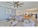 Spacious living room with a large sectional sofa, ceiling fan, and open access to kitchen and dining area at 11924 Brighton Knoll Loop, Riverview, FL 33579