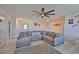 Spacious living room featuring a large sectional sofa, a ceiling fan, and ample natural light at 11924 Brighton Knoll Loop, Riverview, FL 33579