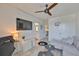 Living room featuring a ceiling fan, grey sofa, tv, gaming chair, and view into the bathroom at 11924 Brighton Knoll Loop, Riverview, FL 33579