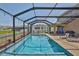 Inviting pool inside lanai offers lounge area and lake views at 11924 Brighton Knoll Loop, Riverview, FL 33579
