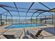 Relaxing screened-in pool area with lounge chairs and a scenic lake view with a fountain at 11924 Brighton Knoll Loop, Riverview, FL 33579