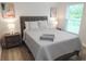 Cozy bedroom with a wooden bed frame, soft bedding, and a bright window view at 12106 Clarendon Ave, Port Charlotte, FL 33981