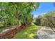 Private backyard view featuring mature trees and lush landscaping along a canal at 1240 Harbor Lake Dr, Largo, FL 33770
