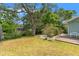 An expansive backyard with mature trees features a lush lawn and patio area, perfect for outdoor enjoyment and relaxation at 1240 Harbor Lake Dr, Largo, FL 33770