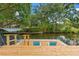 Waterfront backyard dock with a canopy swing, seating and lush landscaping at 1240 Harbor Lake Dr, Largo, FL 33770