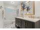 Bathroom featuring a dual sink vanity, custom tile flooring, and shower-tub combo at 1240 Harbor Lake Dr, Largo, FL 33770