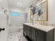 Bathroom featuring a dual sink vanity, custom tile flooring, and shower-tub combo at 1240 Harbor Lake Dr, Largo, FL 33770