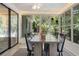 Enclosed sun room featuring a ceiling fan, dining table, windows with backyard views, and a textured rug at 1240 Harbor Lake Dr, Largo, FL 33770