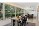 Enclosed sun room featuring a dining table and seating, backyard views, and modern lighting at 1240 Harbor Lake Dr, Largo, FL 33770