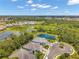 An aerial shot of homes with lush greenery, featuring a tranquil pond, provides a scenic view at 12817 Cobalt Ter, Bradenton, FL 34211