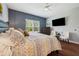 Bedroom featuring a ceiling fan, large window, and stylish decor creating a relaxing retreat at 12817 Cobalt Ter, Bradenton, FL 34211