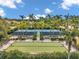 Aerial view of palm-lined tennis courts and a bocce ball court with benches, creating a lovely recreational area at 12817 Cobalt Ter, Bradenton, FL 34211