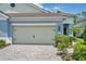 Charming home with a two-car garage, lush landscaping, and a paved driveway leading up to the entrance at 12817 Cobalt Ter, Bradenton, FL 34211
