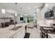 Modern kitchen with white cabinets, island with seating, and view into the living room at 12817 Cobalt Ter, Bradenton, FL 34211