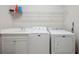 Laundry room featuring a washing machine, dryer, utility sink, storage cabinets, and a wire shelf at 12817 Cobalt Ter, Bradenton, FL 34211