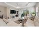 Bright living room featuring white sofas, ceiling fan, and view of screened outdoor patio at 12817 Cobalt Ter, Bradenton, FL 34211