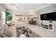 Bright, open-concept living room with modern decor, adjacent to dining area and kitchen with bar seating at 12817 Cobalt Ter, Bradenton, FL 34211
