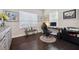 Home office with dark wood floors, accent bench, and two windows for plenty of light at 12817 Cobalt Ter, Bradenton, FL 34211