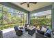 Screened-in patio with four cushioned chairs surrounding a gas fire pit and lush outdoor views at 12817 Cobalt Ter, Bradenton, FL 34211