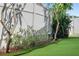 Manicured yard showcasing lush greenery, flower beds, and a pristine artificial turf at 13035 91St Ave, Seminole, FL 33776