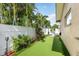 Landscaped backyard features putting green, tropical plants, and privacy fence, perfect for outdoor relaxation at 13035 91St Ave, Seminole, FL 33776