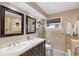 Bathroom featuring a double vanity, tiled shower, and warm, neutral color palette at 13035 91St Ave, Seminole, FL 33776