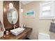 Stylish bathroom with a wood vanity, modern vessel sink, pendant lights, and decorative touches at 13035 91St Ave, Seminole, FL 33776