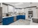 Stylish kitchen with white and blue cabinetry, modern appliances, and bright countertops with decorative backsplash at 13035 91St Ave, Seminole, FL 33776