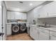 Laundry room with sleek, modern appliances, ample counter space, and white cabinetry at 13035 91St Ave, Seminole, FL 33776