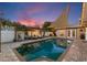 Inviting pool with a pergola, lounge chairs, and outdoor lighting creating a relaxing backyard oasis at twilight at 13035 91St Ave, Seminole, FL 33776