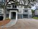 Condo exterior with gray paint, private garages, and balconies offers modern living at 13243 Sanctuary Cove Dr # 204, Temple Terrace, FL 33637