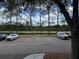Parking lot with lined spaces, tall pines, a pond, and views of mature landscaping at 13243 Sanctuary Cove Dr # 204, Temple Terrace, FL 33637