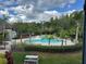 Community pool surrounded by lush landscaping, sun loungers, and palm trees, offering a tranquil retreat at 13243 Sanctuary Cove Dr # 204, Temple Terrace, FL 33637