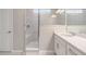 Bright bathroom featuring a glass enclosed shower with bench, a large vanity, and a window for natural light at 13614 Stevenson Ln, Odessa, FL 33556