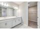 Bathroom features a double sink vanity, a large mirror, and a walk-in closet for extra storage at 13614 Stevenson Ln, Odessa, FL 33556