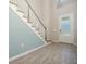Bright foyer with light blue accent wall, wood-look tile flooring, staircase and glass panel front door at 13614 Stevenson Ln, Odessa, FL 33556