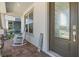 Inviting front porch with rocking chairs and a decorative 'HELLO' sign by the textured front door at 13614 Stevenson Ln, Odessa, FL 33556