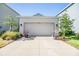 Spacious two car garage with a concrete driveway and lovely landscaping at 13614 Stevenson Ln, Odessa, FL 33556