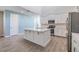 Open kitchen with island, stainless steel appliances, and white cabinets; open to a dining and living area at 13614 Stevenson Ln, Odessa, FL 33556