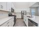 Bright kitchen with stainless steel appliances, quartz counters, and ample storage in white cabinets at 13614 Stevenson Ln, Odessa, FL 33556