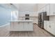 Bright open kitchen featuring an island, stainless appliances, and modern white cabinetry at 13614 Stevenson Ln, Odessa, FL 33556