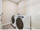 Convenient laundry room with a white front-load washer and dryer and wire shelving above at 13614 Stevenson Ln, Odessa, FL 33556