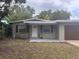 Charming single-story home featuring a neutral exterior, a well-manicured lawn and a covered porch at 1388 Browning St, Clearwater, FL 33756
